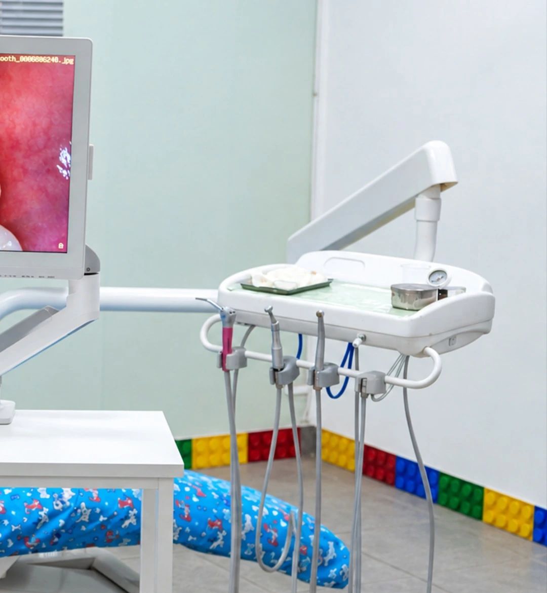 El consultorio infantil, con la unidad dental, el monitor junto al sillón y un zócalo de bloques de colores